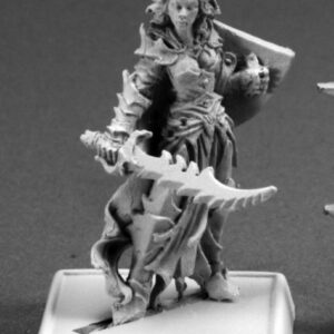 A female dark elf fighter standing defensively. She is dressed in ornate armour with a long loincloth and cloak. She holds a shield close to her body with one hand. Her other holds her jagged bladed sword low across the front of her body.
